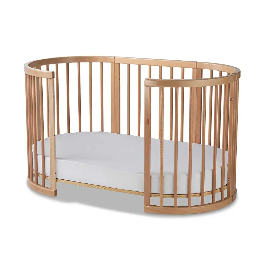 Oval wooden baby crib with white mattress from Lolli Sprout Cot in Toshi Baby European Beech Wood