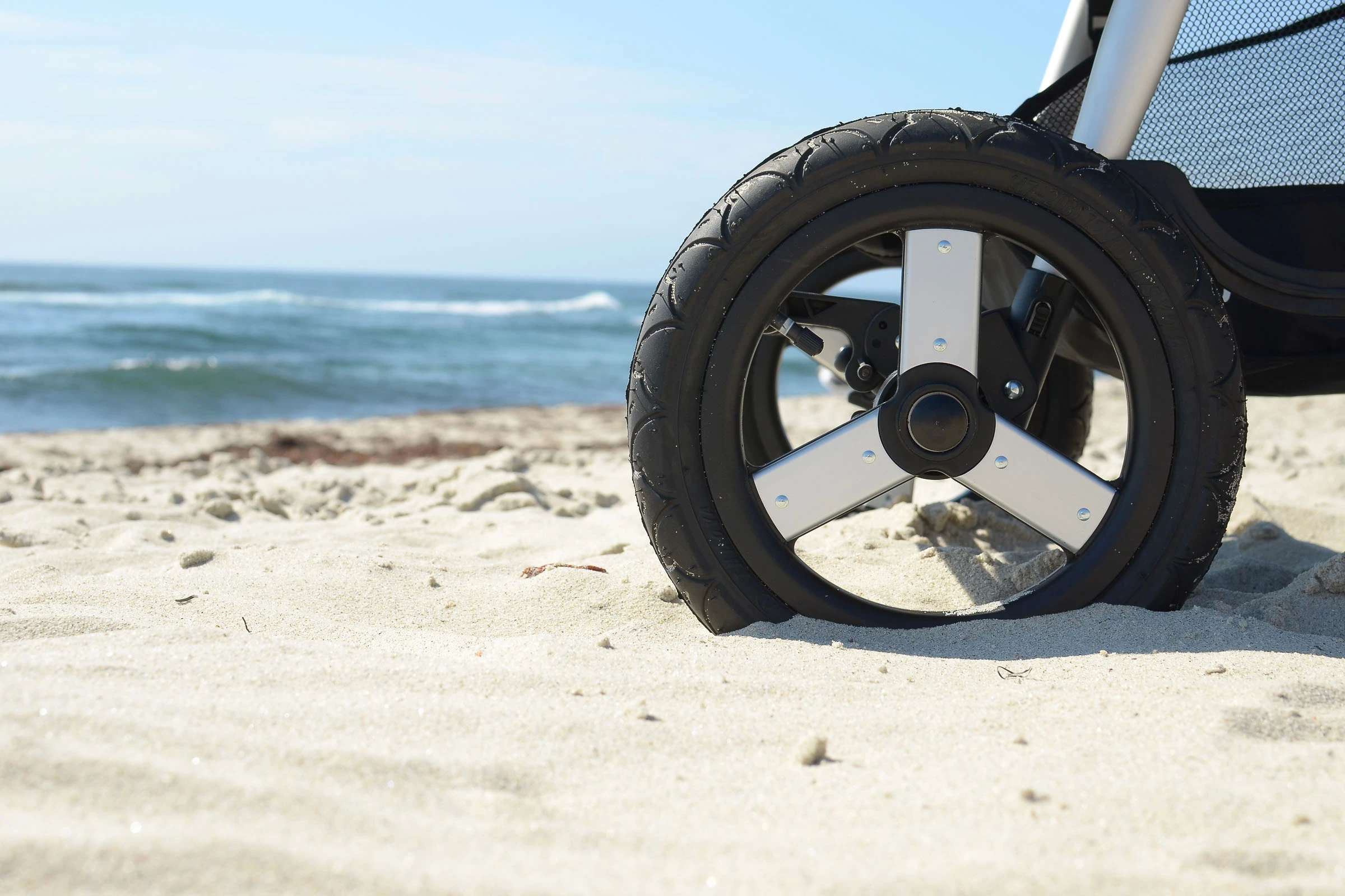 Bumbleride Indie Stroller wheel on sand with Odyssey wagon wheels detail