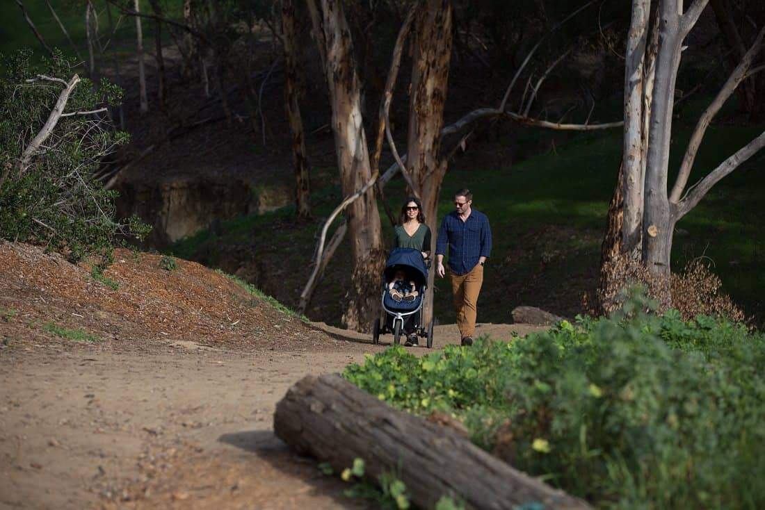 Family walking with Bumbleride Indie Stroller, perfect for baby strollers and Toshi Baby Romper