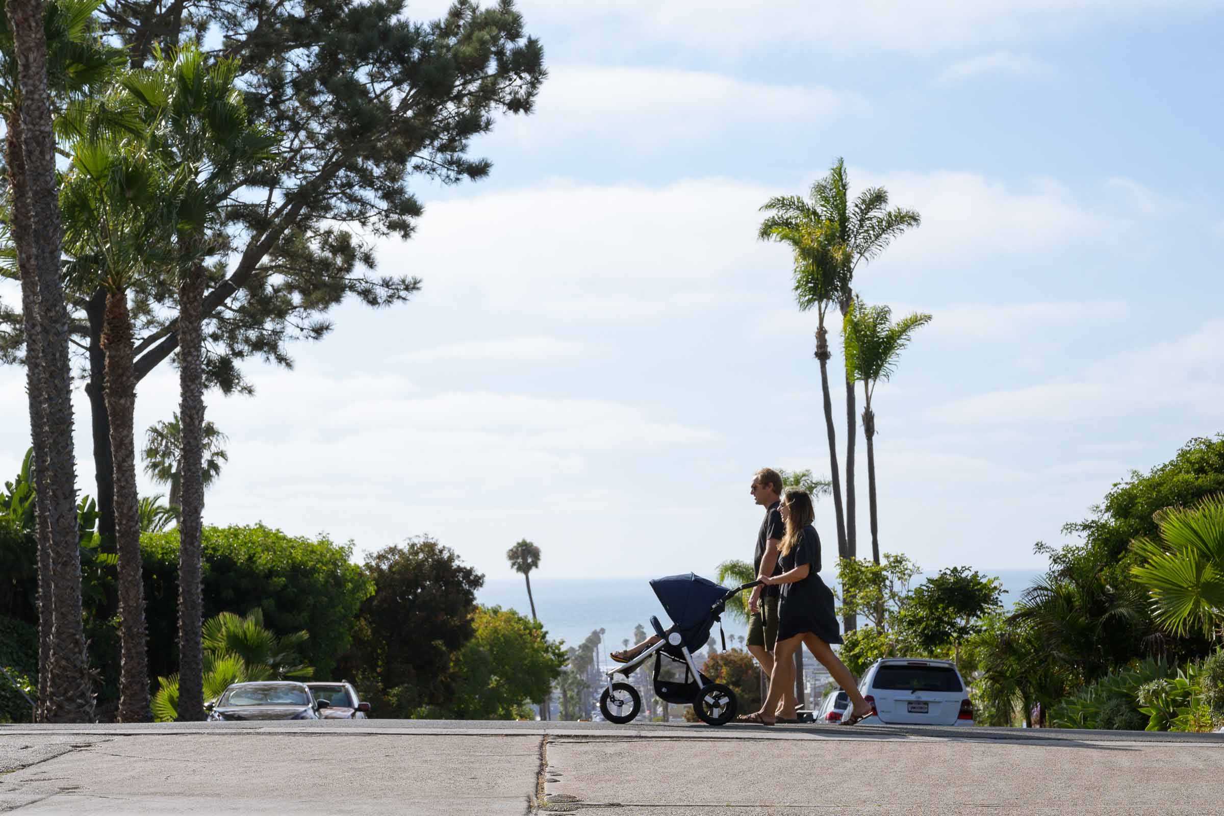 Couple pushing stroller with Odyssey wagon wheels using Bumbleride Indie Stroller in park