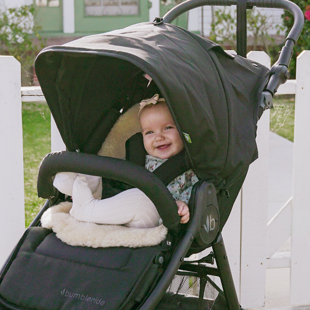 Black Bumbleride Indie Stroller with smiling infant in Toshi Baby Romper, great baby strollers