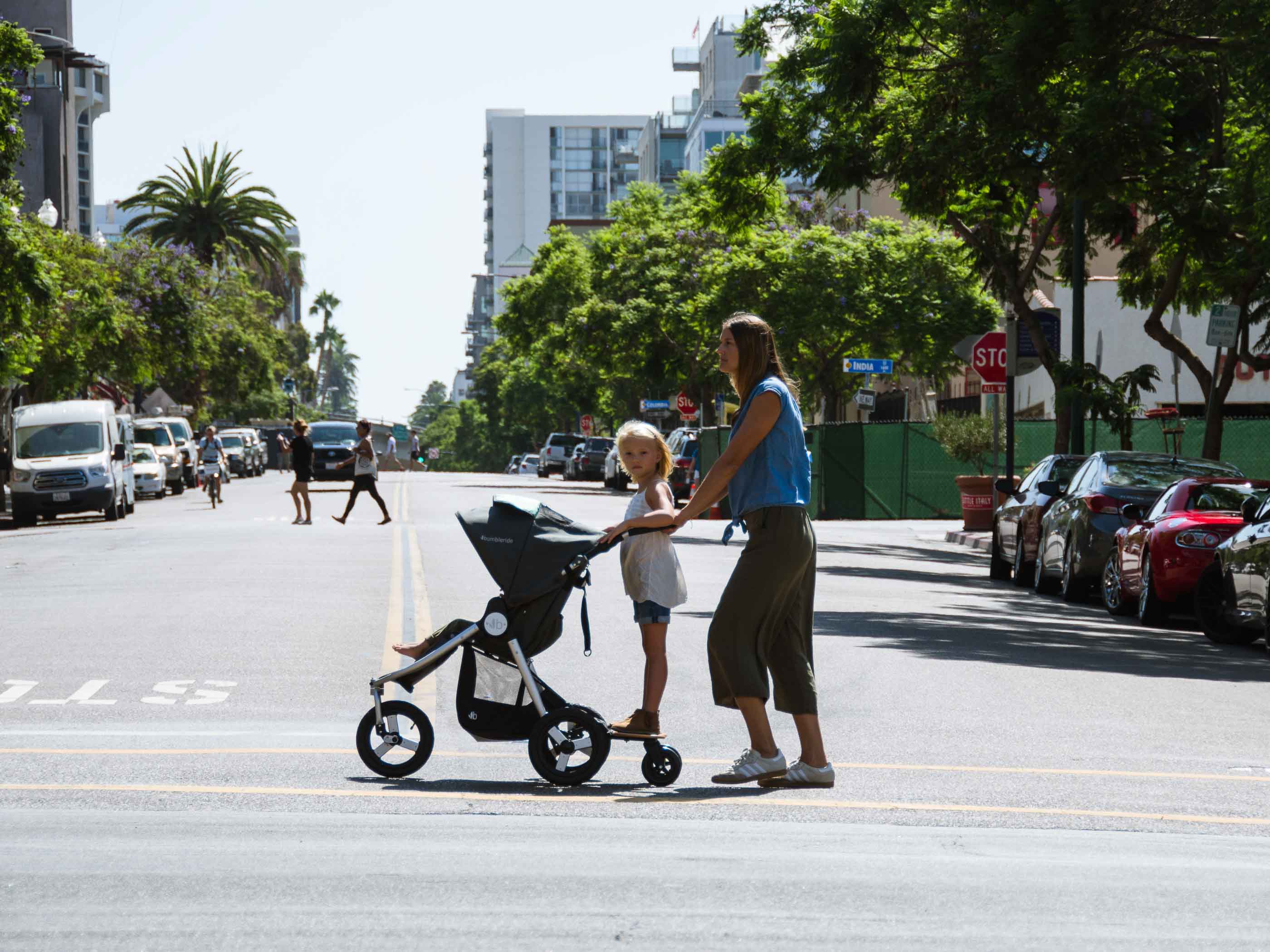 Mother pushing a Bumbleride Indie Stroller with child in Odyssey wagon wheels