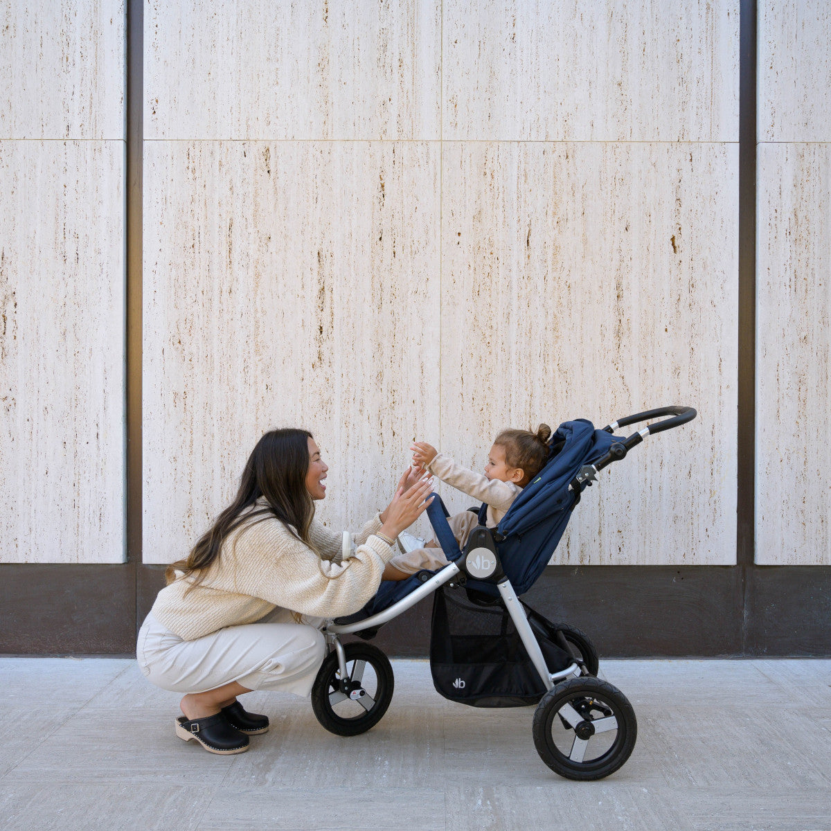 Navy blue Bumbleride Indie Stroller with Odyssey wagon wheels perfect for Toshi Baby Romper outings