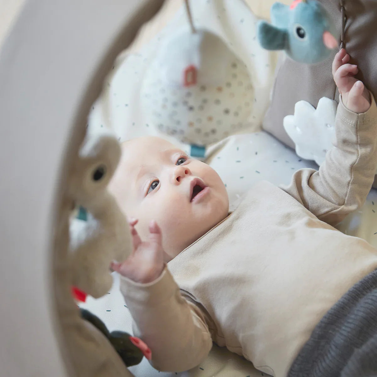 Baby lying in the award-winning Done by Deer Activity Gym SAND with Toshi Baby Romper