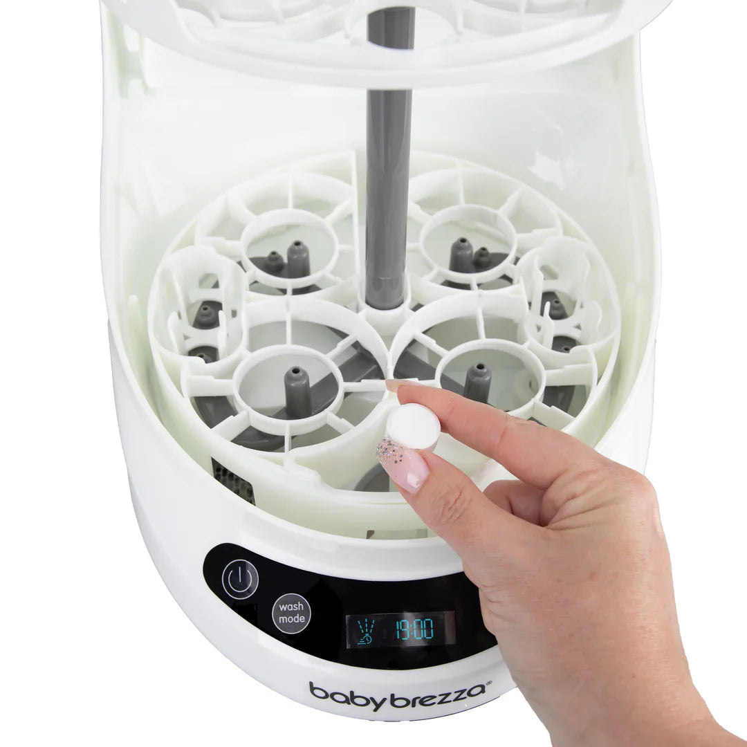 White baby bottle sterilizer with Baby Brezza descaling tablets for clean bottles