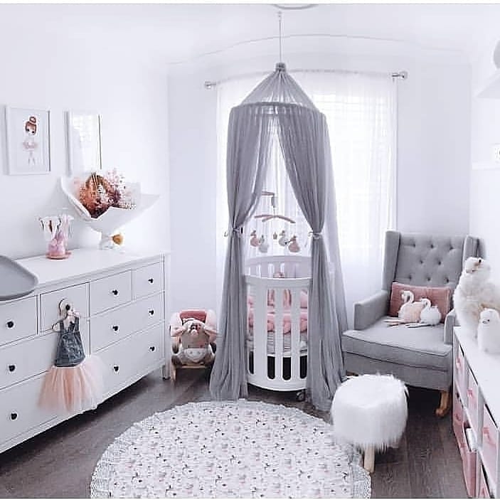 Beautifully designed cocoon nest cot in a baby’s room with round crib and gray canopy