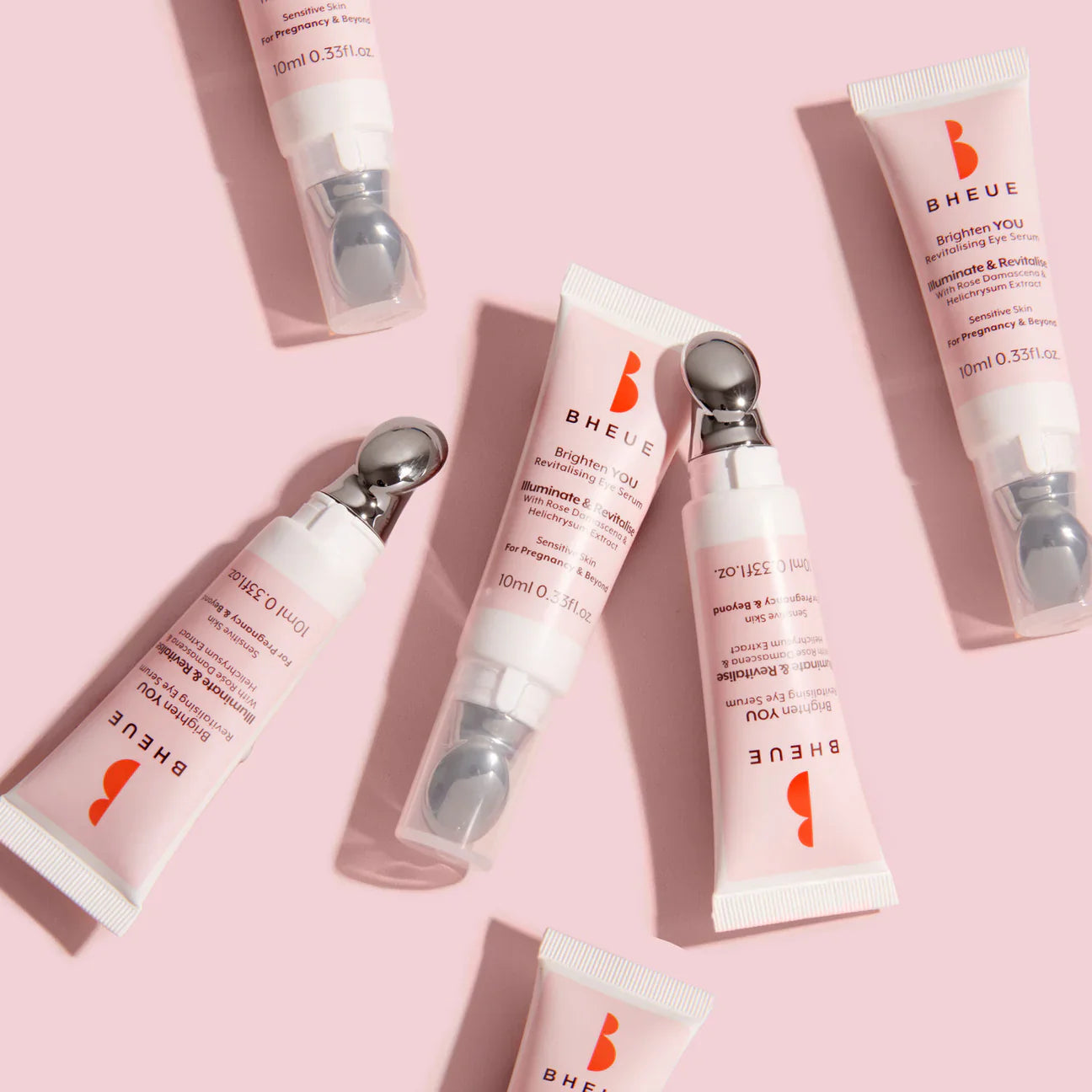 Pink eye cream tubes with metal rollerball applicators for Bheue Brighten revitalising eye serum