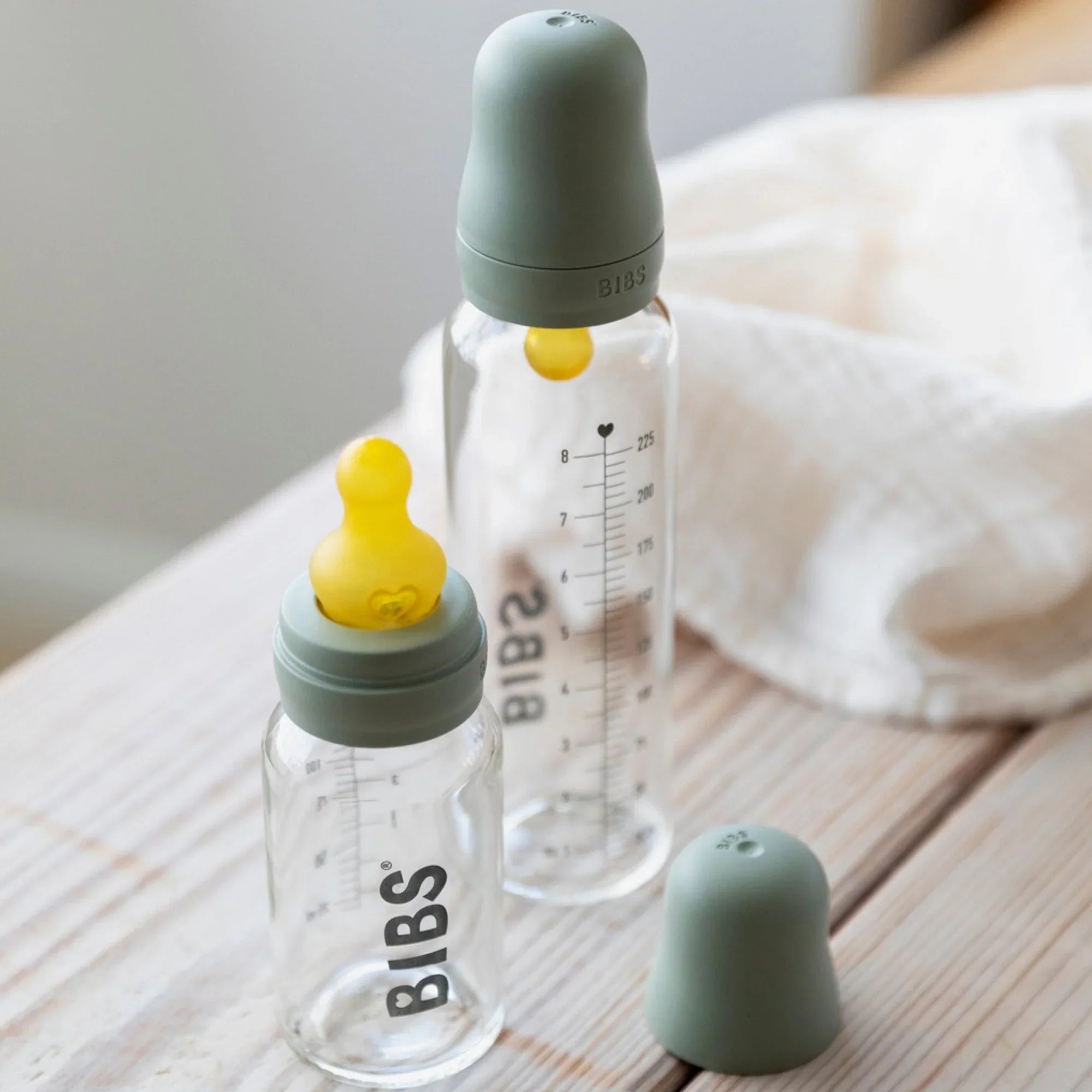 Toshi Baby Bibs 225ml Glass Bottle Set with clear bottles, green caps, and yellow nipples