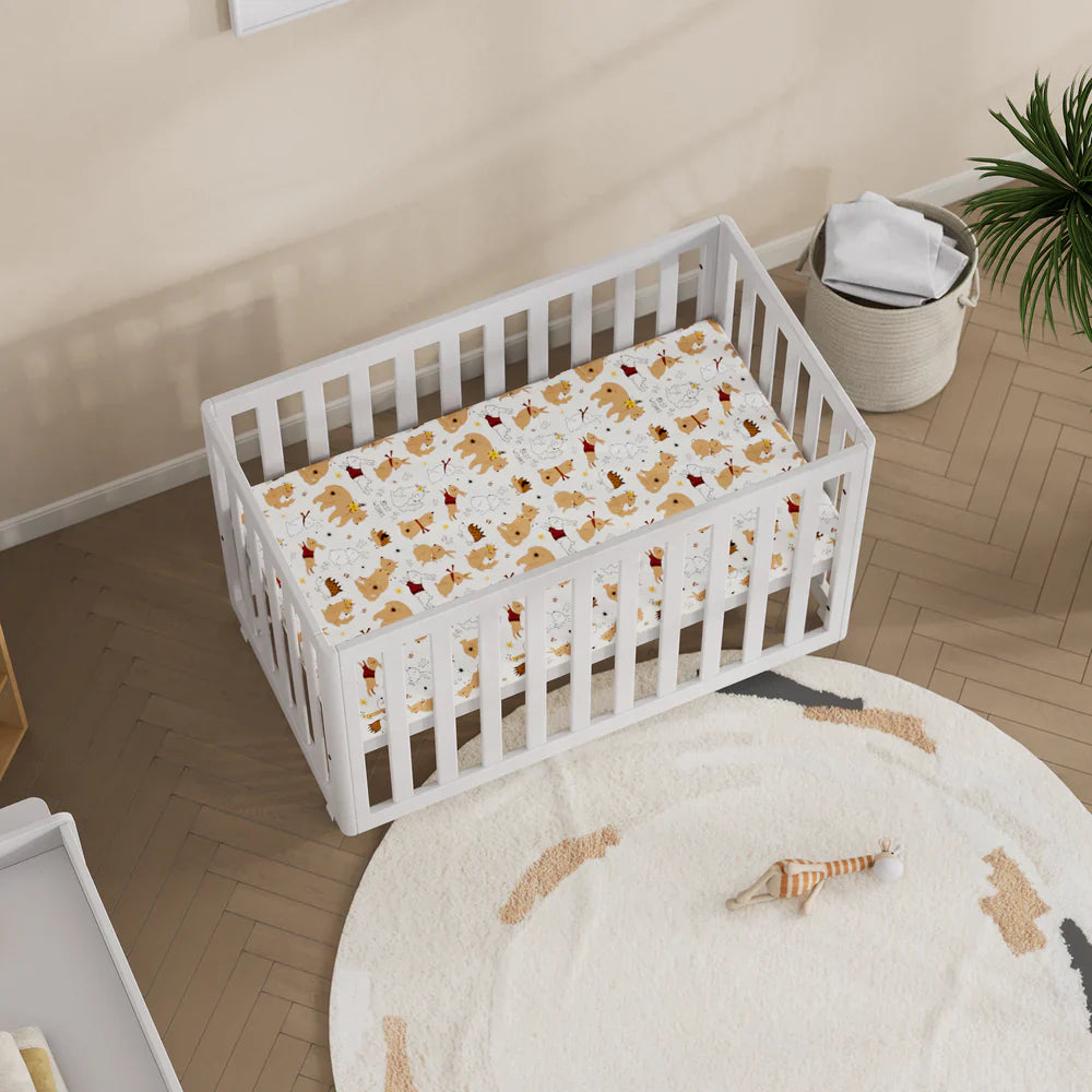 White baby crib with patterned sheet from Boori Turin Compact Cot with pocket spring mattress