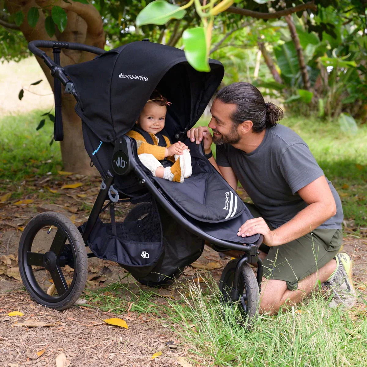 Black Bumbleride Speed Stroller with Odyssey wagon wheels, perfect for Toshi baby romper outings