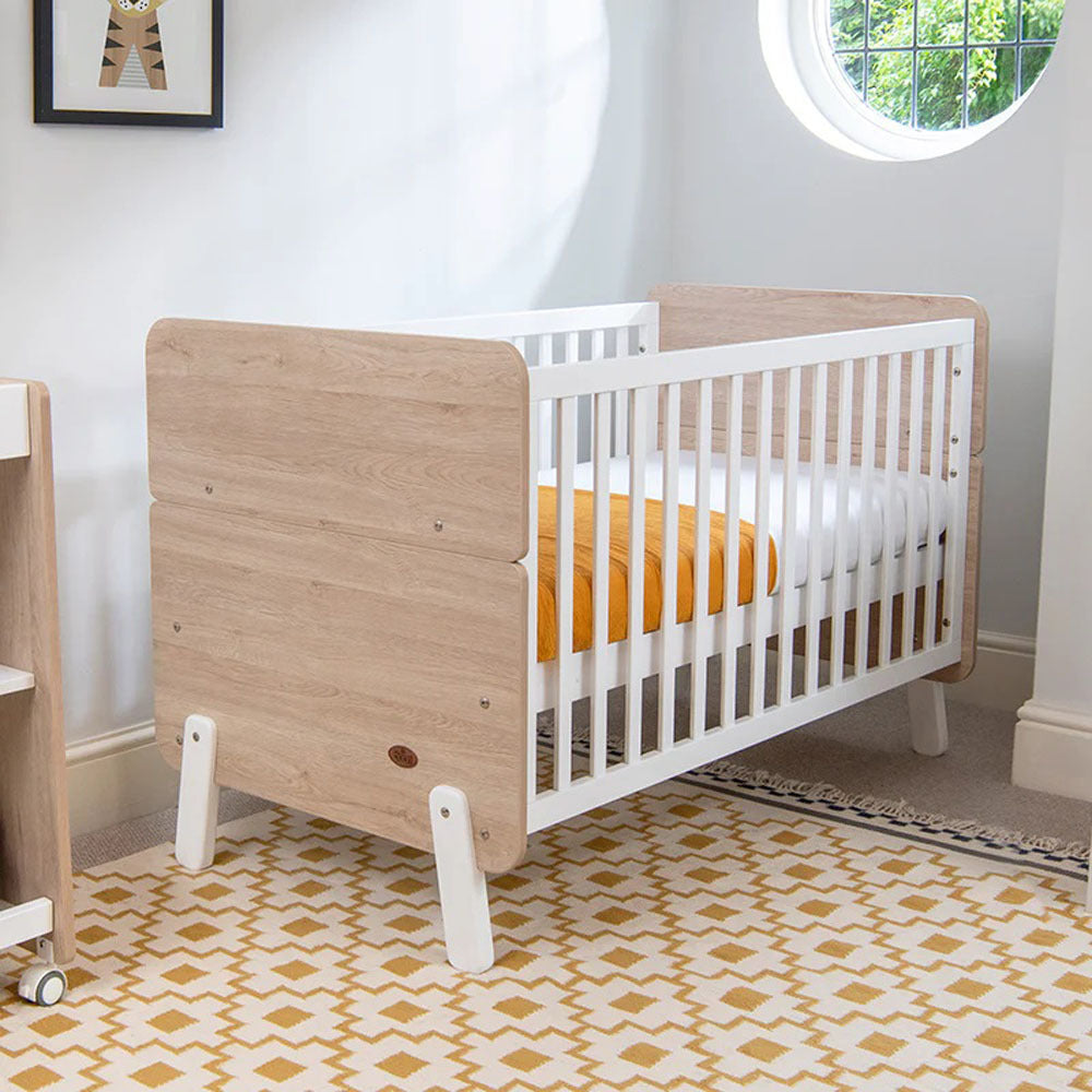 Wooden and white baby crib from Boori Natty Cot Bed and Mattress Package with toshi baby romper
