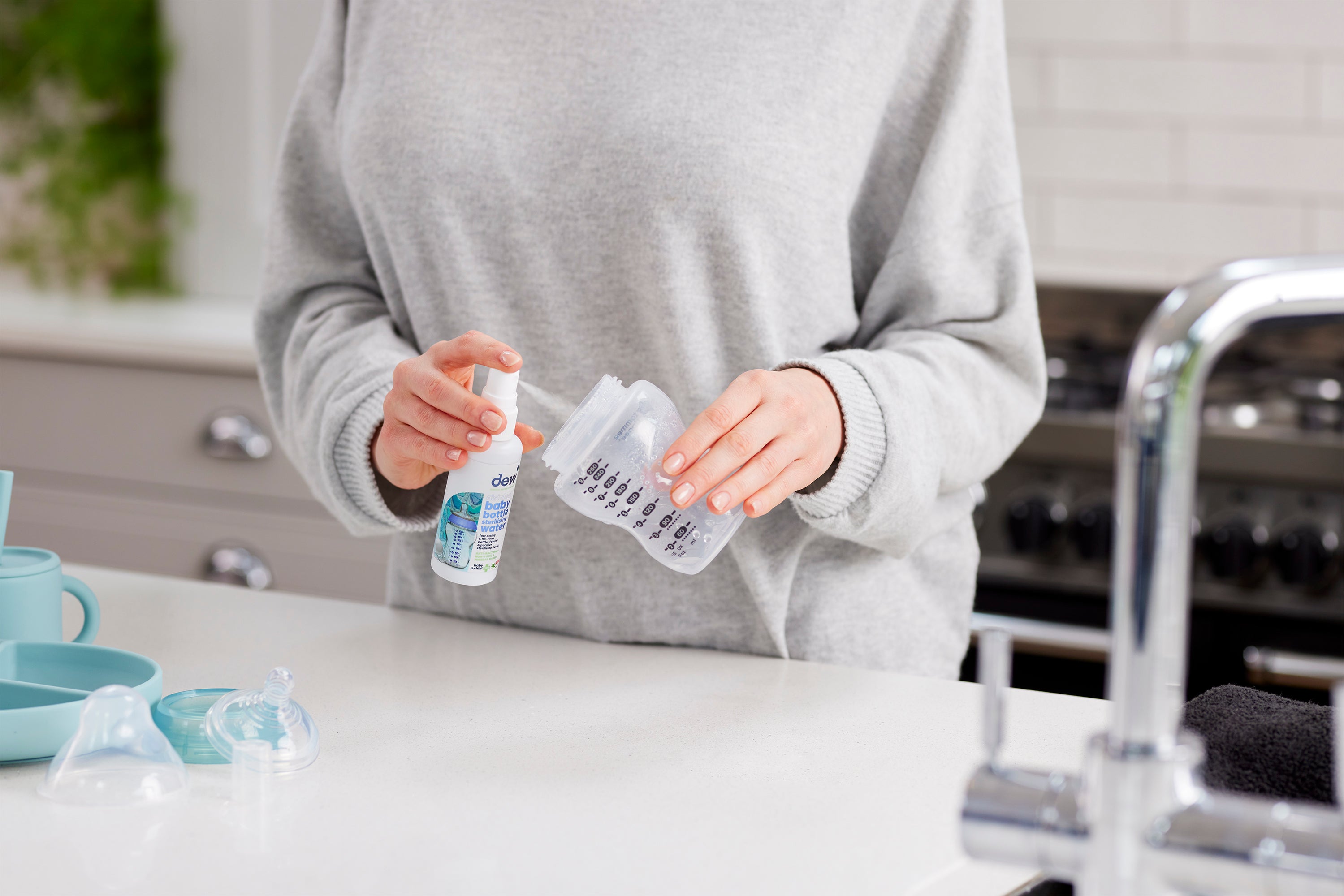 Baby bottle being sanitized with Dew Baby Bottle Sterilising Water 65ml, perfect for clean baby bottles