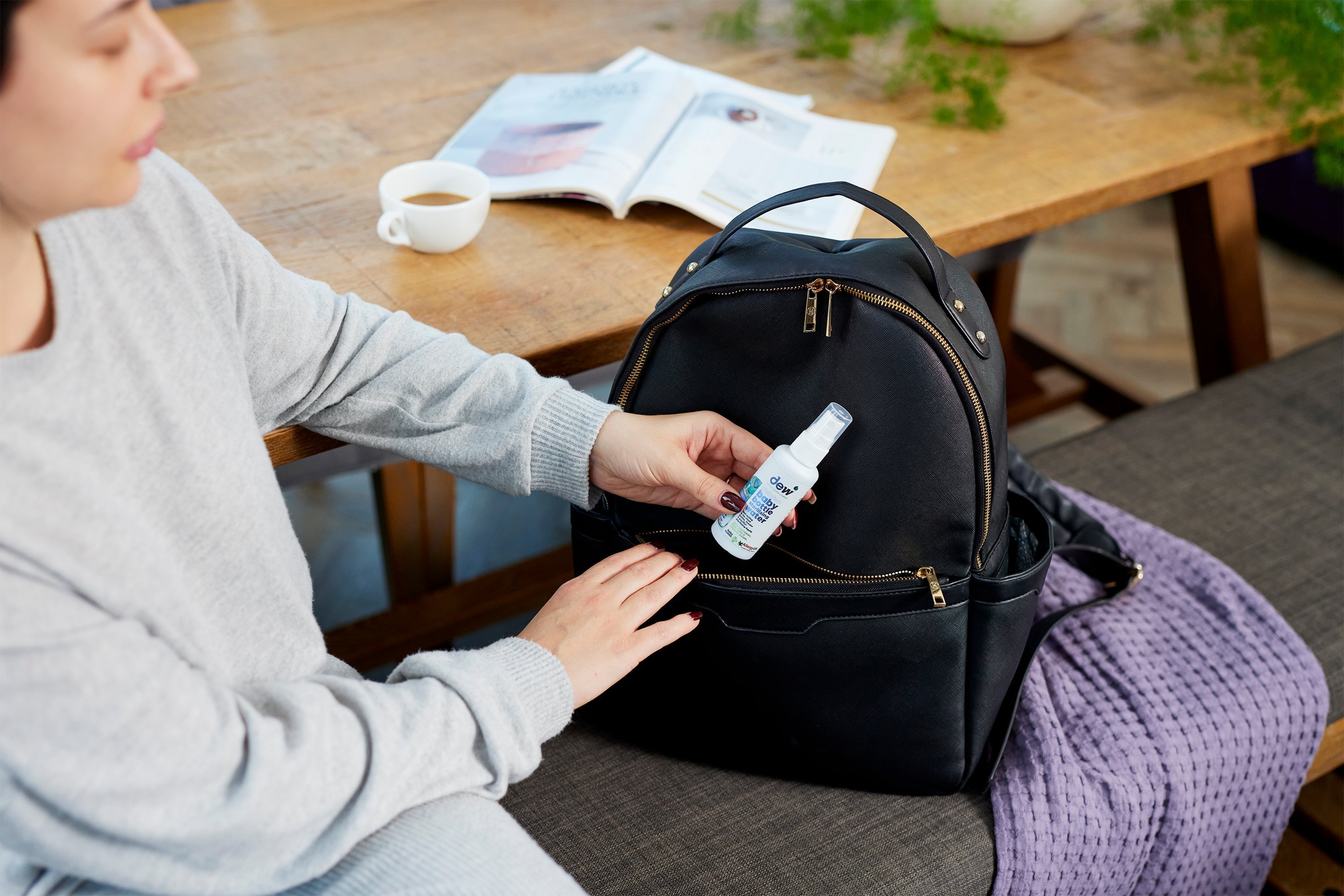 Black backpack with gold zippers for carrying Dew Baby Bottle Sterilising Water 65ml