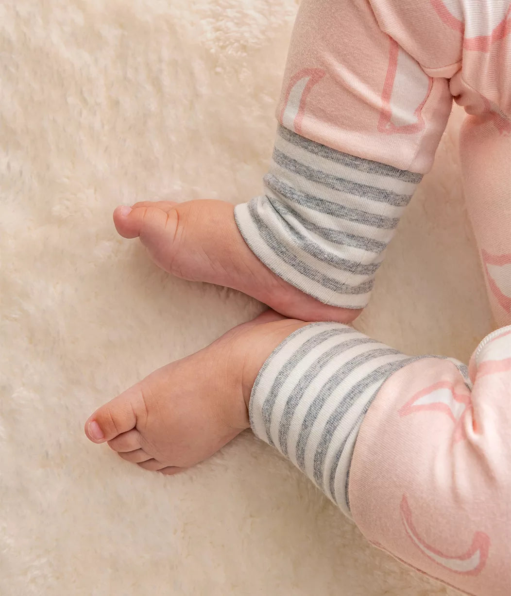 Baby’s feet in striped-cuffed pajamas from Love To Dream Enclosed Foot Romper Dusy Pink