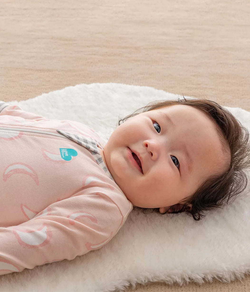 Smiling baby in dusy pink Love To Dream Enclosed Foot Romper, perfect for toshi baby and baby strollers