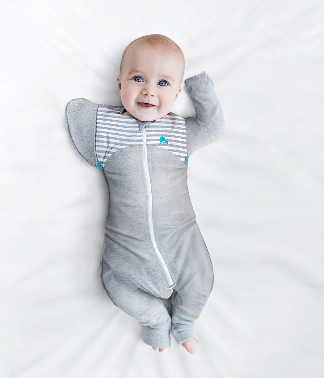 Baby in gray striped sleep sack wearing Love To Dream Swaddle Transition Suit dream™ transition suit for toshi baby
