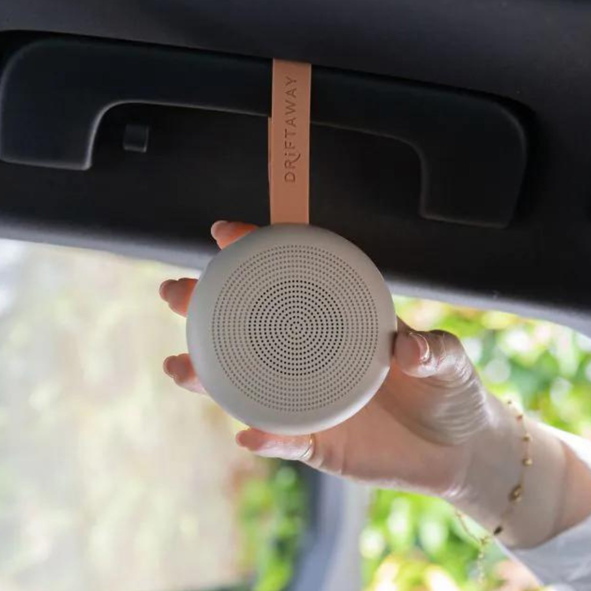 Round white speaker with leather strap for portable white noise and ErgoPouch Drift Sleep Sounds on baby strollers