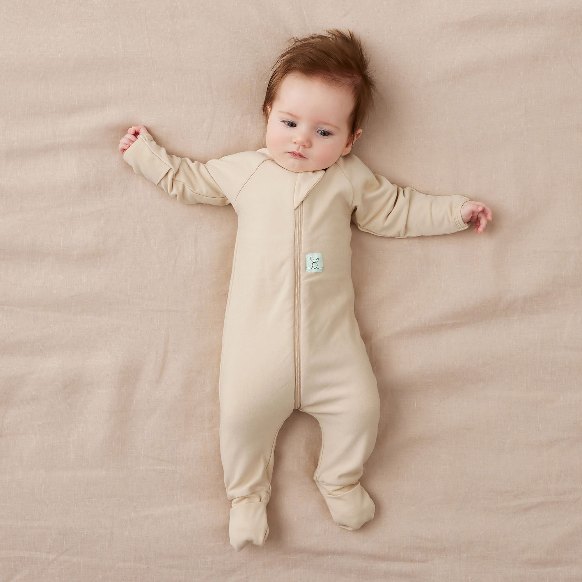 Baby in beige ergopouch long sleeve organic jersey cotton pajamas, perfect with baby strollers