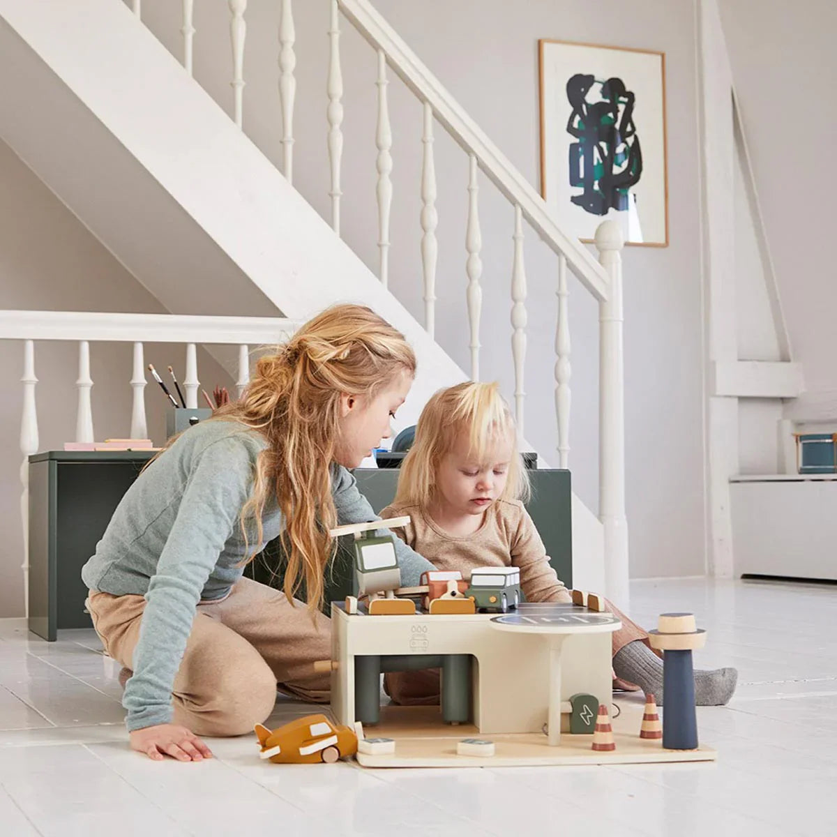 Kids playing with a Flexa Wooden Parking Garage two-level parking and electric car charger