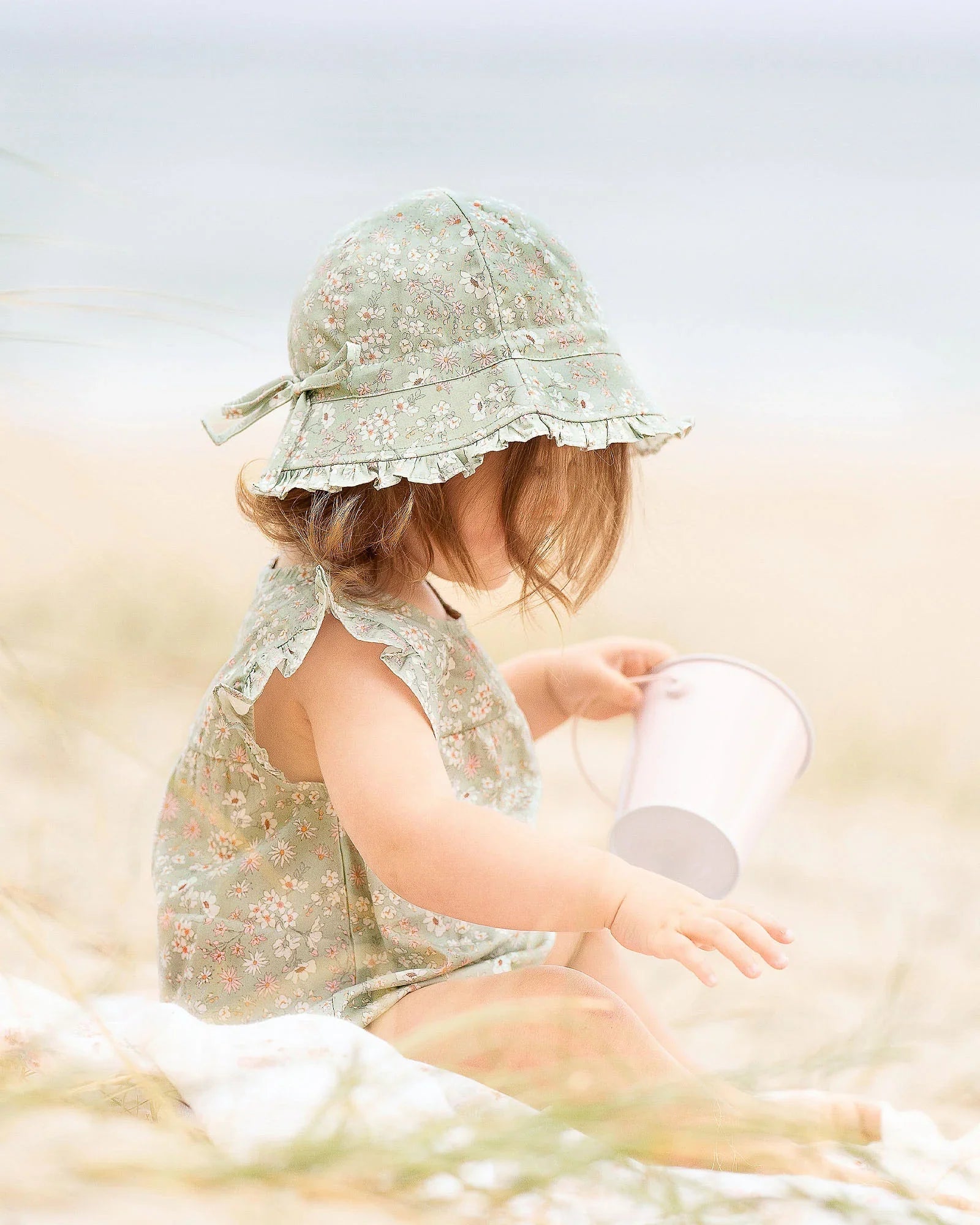 Cute baby with Toshi Bell Hat Eva in floral sunsuit and hat with bucket for baby strollers