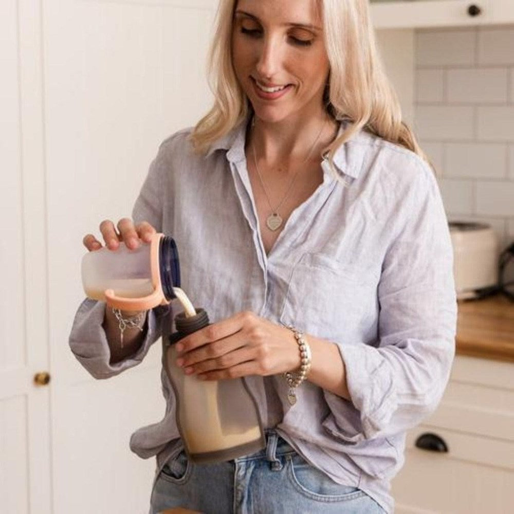 Woman pouring liquid into a Haakaa Silicone Milk Storage Bag for easy baby feeding