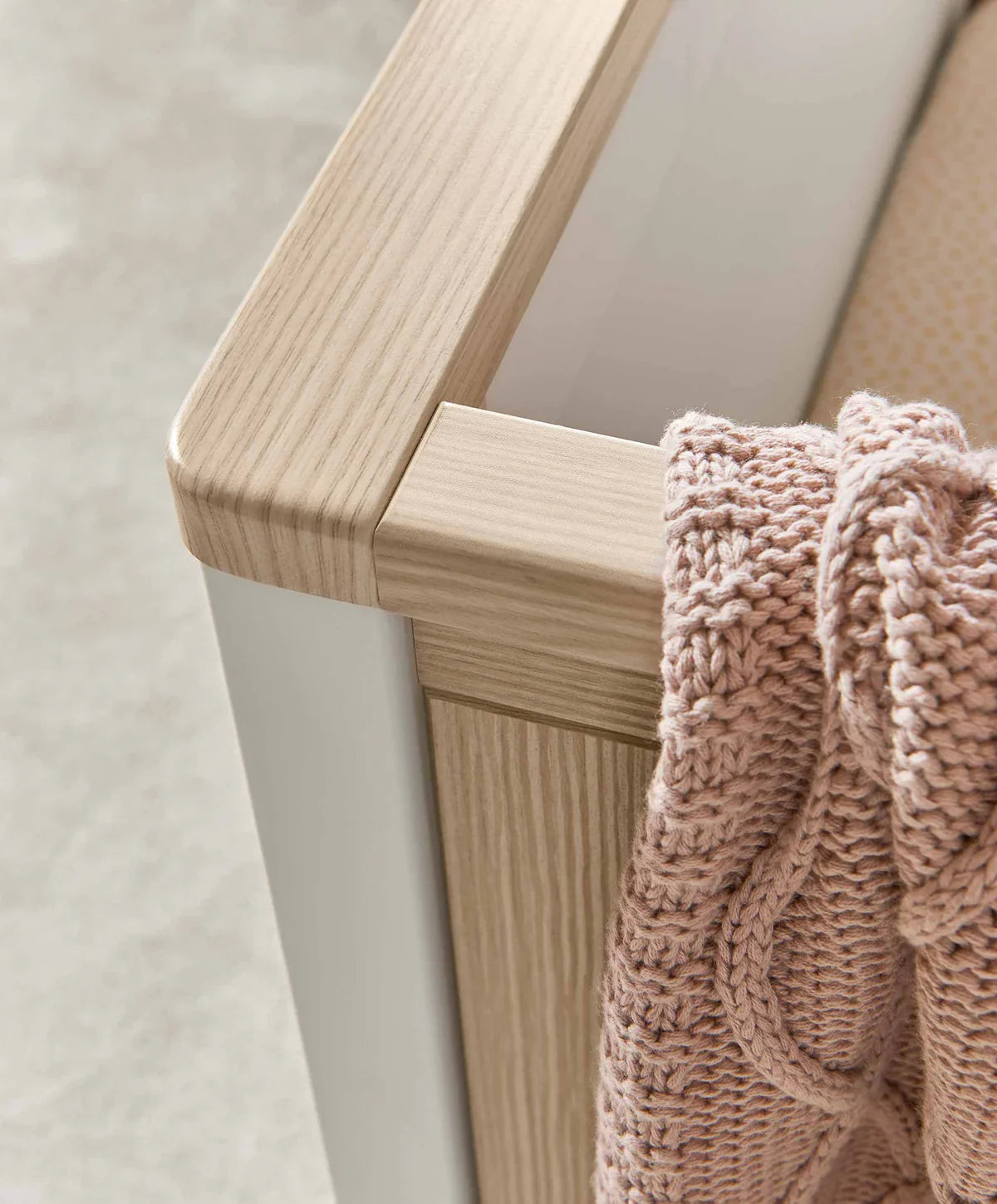 Light wood and white frame cotbed with pink knit blanket in Mamas&Papas Harwell set