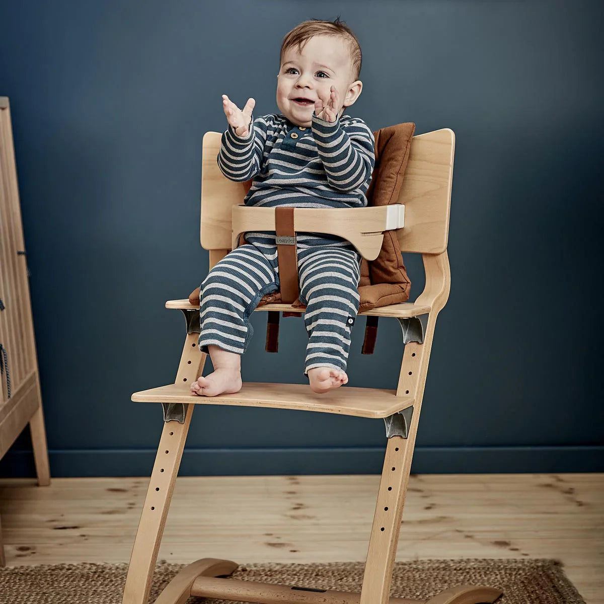 Wooden adjustable high chair with baby, perfect for leander chair safety and postpartum bonding