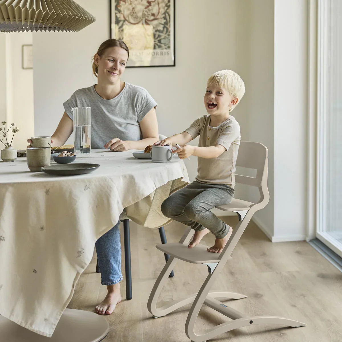 Modern light-colored wooden Leander Louie Highchair perfect with Toshi Baby Romper