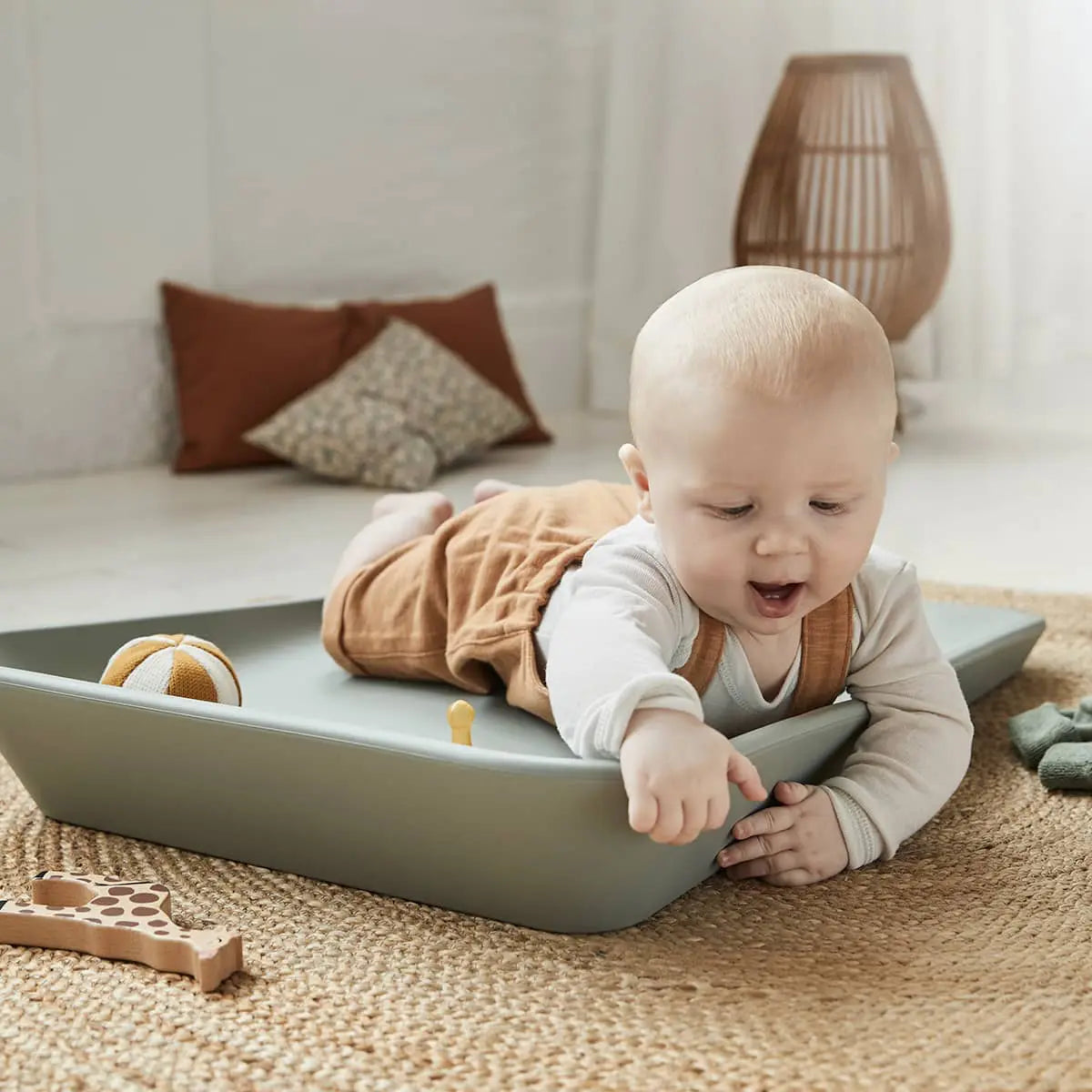 Baby on a sage green Leander Matty Change Mat, perfect for toshi baby and baby strollers