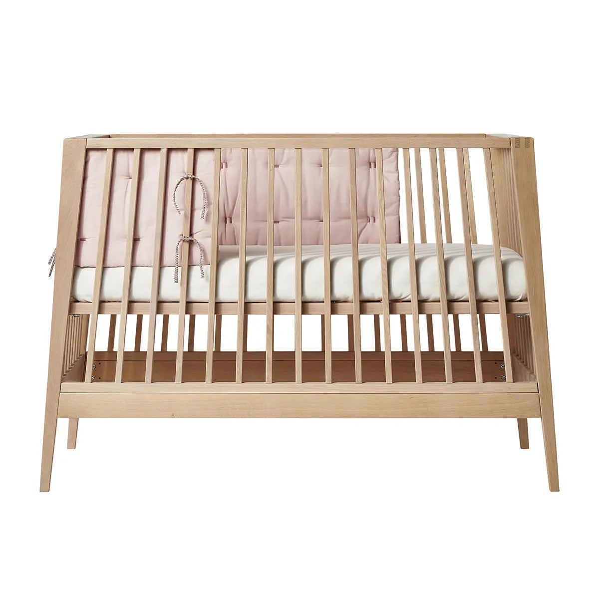 Wooden baby crib with pink bumper from Leander Organic Linea Luna Cot Bumper collection