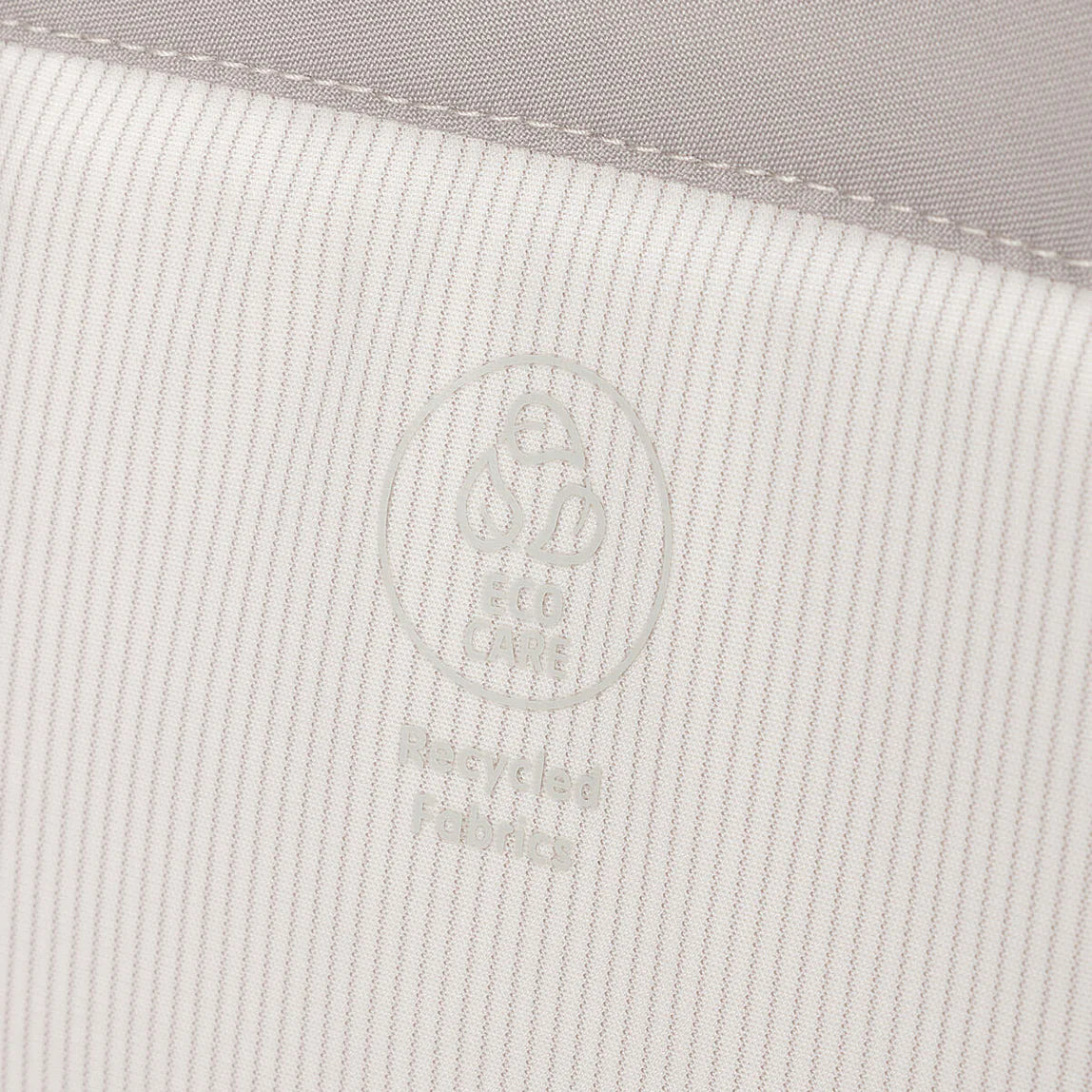 Striped fabric with circular logo on Maxi Cosi Toshi Baby Air Bedside Sleeper