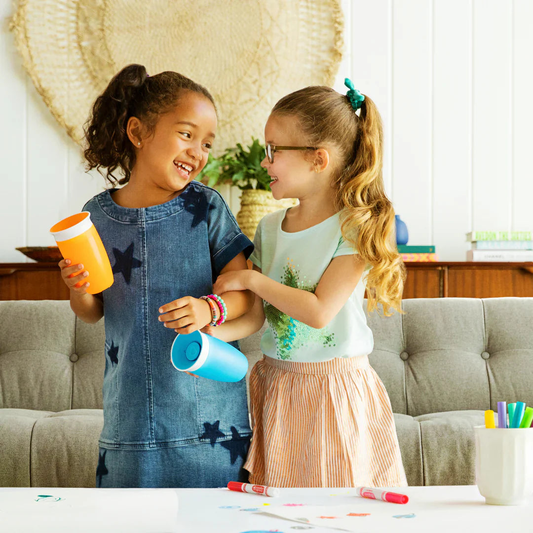 Two young girls holding cups with Munchkin 10oz Miracle® 360° Cup, perfect for baby strollers