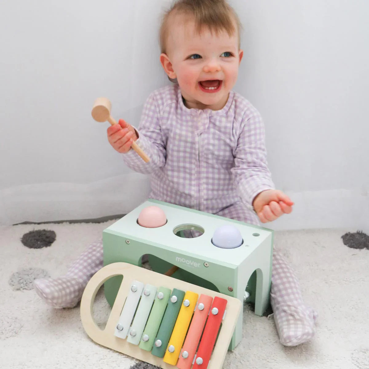 Baby with wooden musical toys for Moover Musical Tap and Toshi Baby Romper playtime