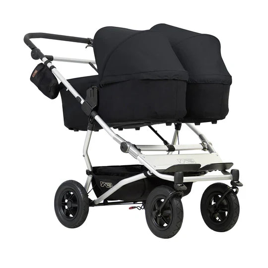 Black double stroller with Mountain Buggy Carrycot Plus for Duet‚Ñ¢ for comfy strolling