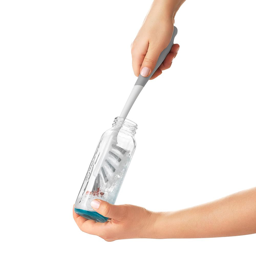 Bottle brush cleaning a glass bottle with OXO Tot Water Bottle and Straw Cup Cleaning Set