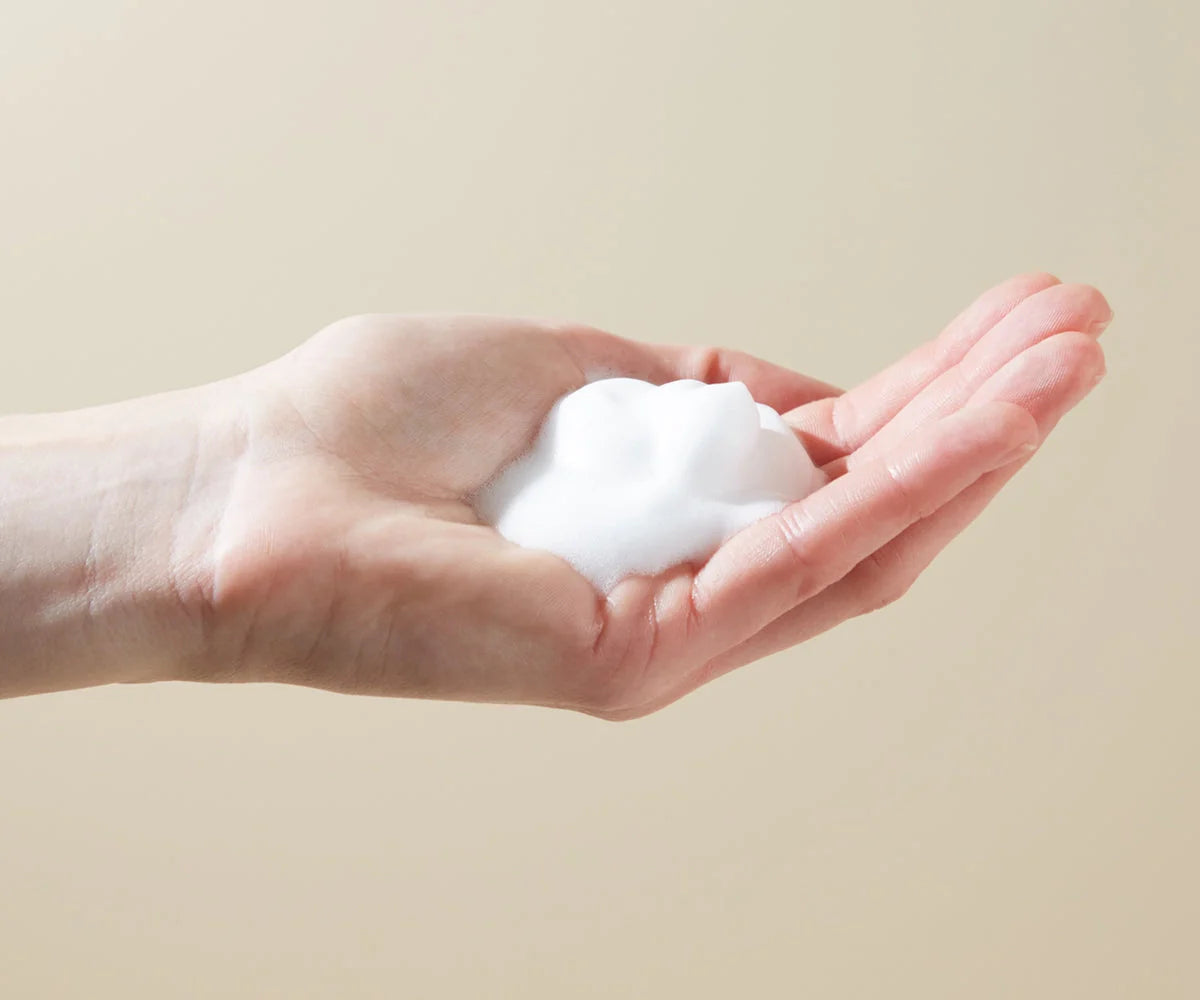 Hand holding white foam for Bare Mum Postpartum soothing witch hazel relief
