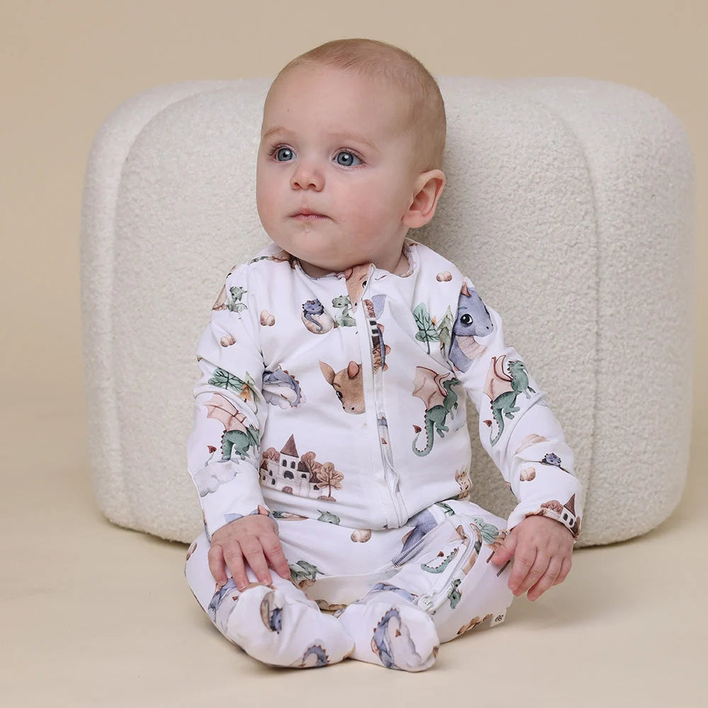 Baby in Toshi Baby organic snuggle sleepsuit zip with dragon theme for cozy naps