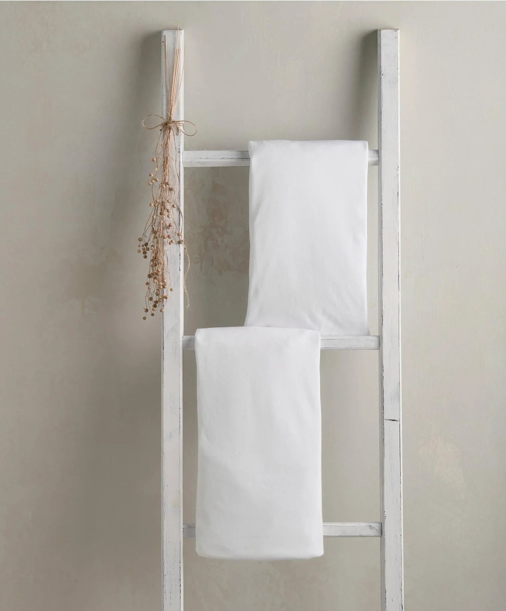 White towels on a ladder with Mamas & Papas Cotbed Fitted Sheets for baby comfort