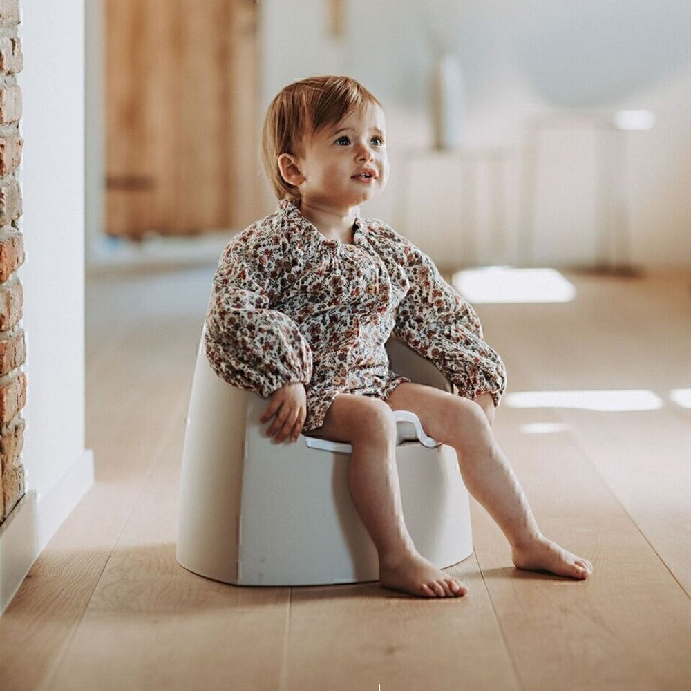 Toddler sitting on Quax My Potty Clay with toshi baby romper, perfect for potty training