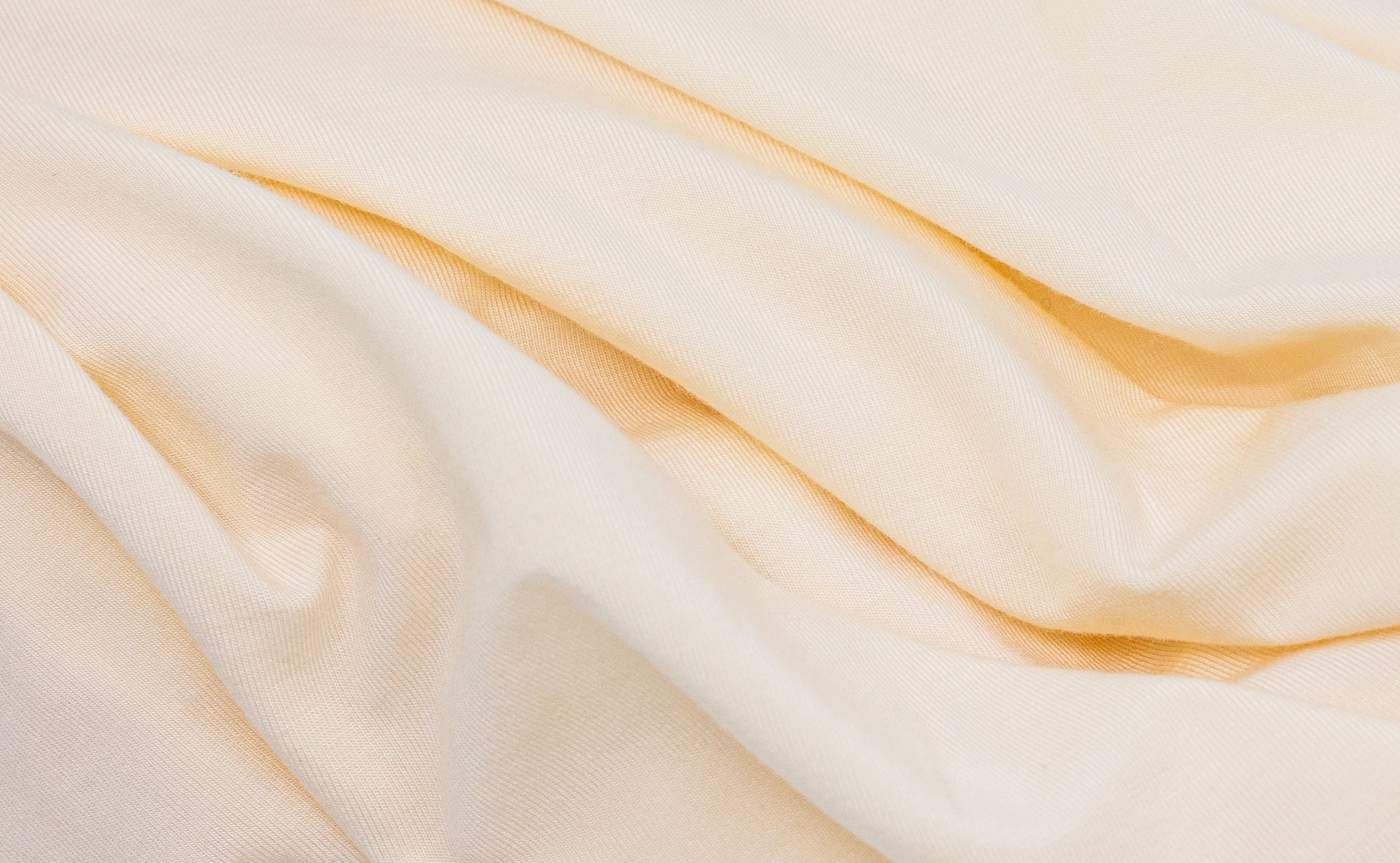 Wrinkled light-yellow fabric from Tasman Eco Fitted sheets perfect for baby strollers