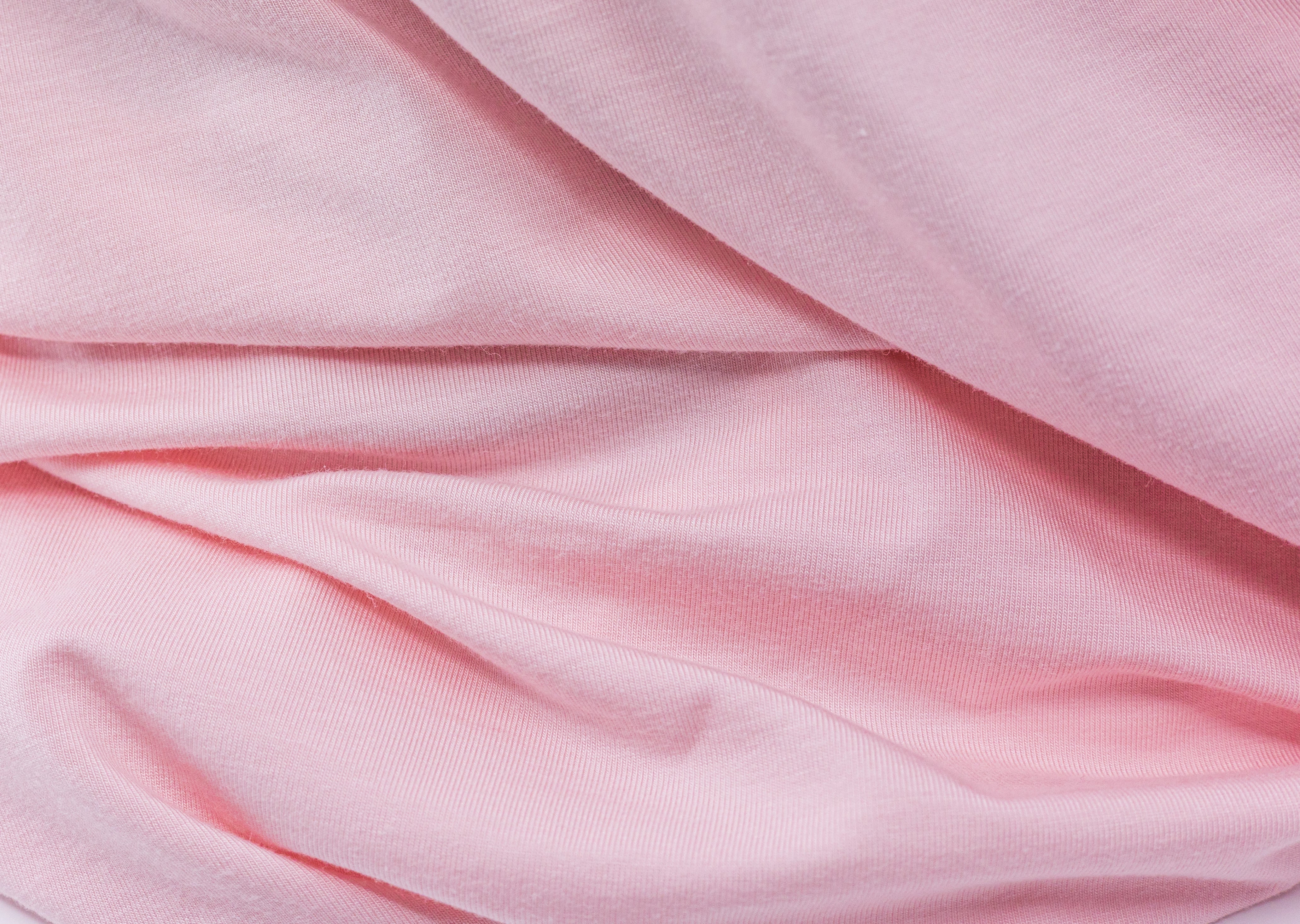 Wrinkled pink fabric from Tasman Eco Fitted sheets perfect for cozy baby and postpartum comfy wear