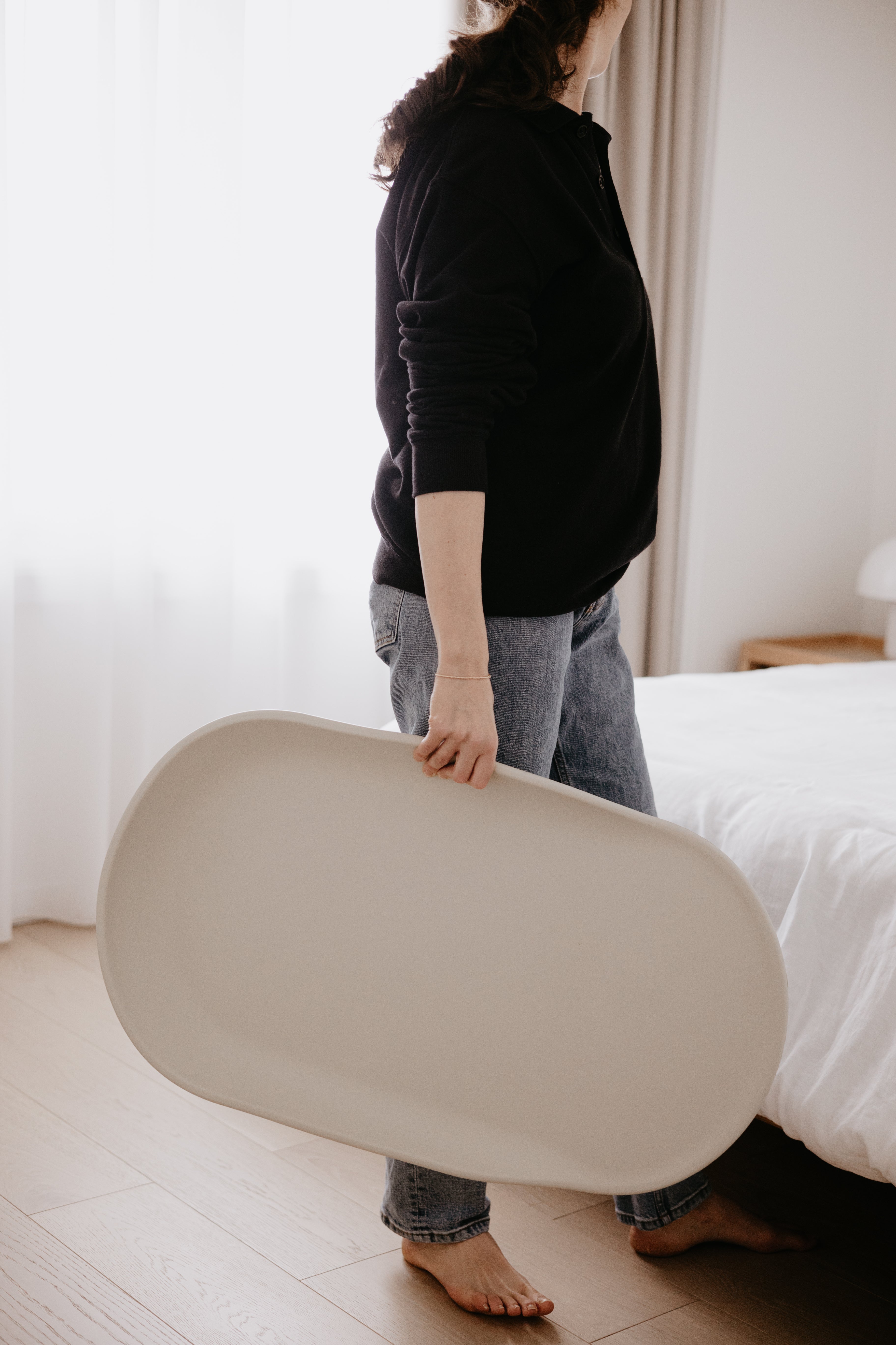 Oval-shaped beige Tasman Eco Touzy Change Mat for Toshi Baby loungers