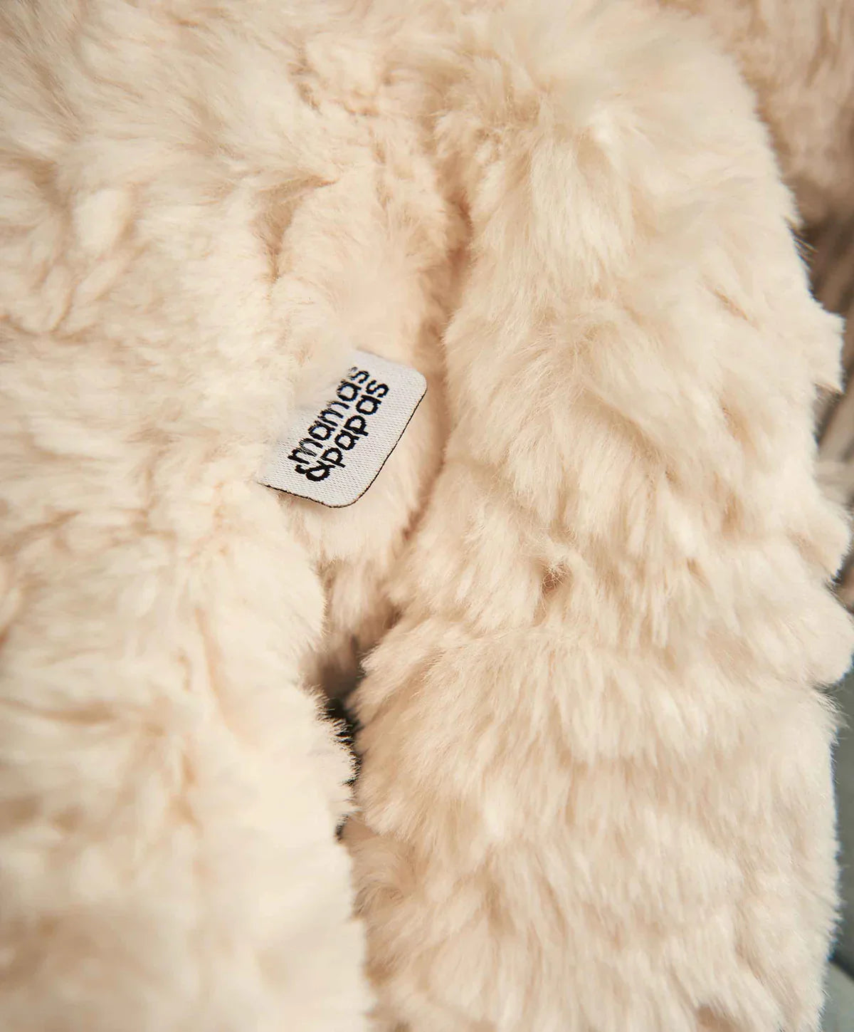 Cream faux fur blanket with tag for babies, perfect for cozy moments in baby strollers