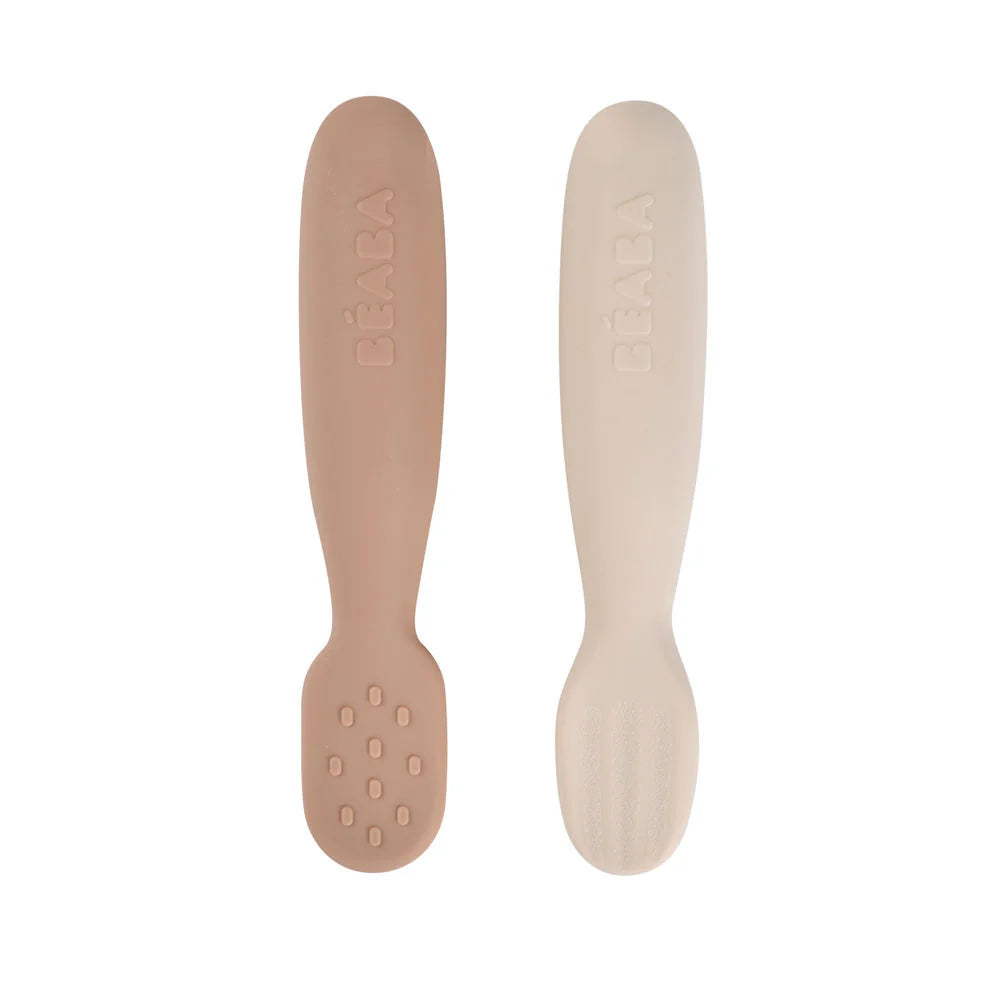 Two baby rattles, one brown and one beige, on a white background.