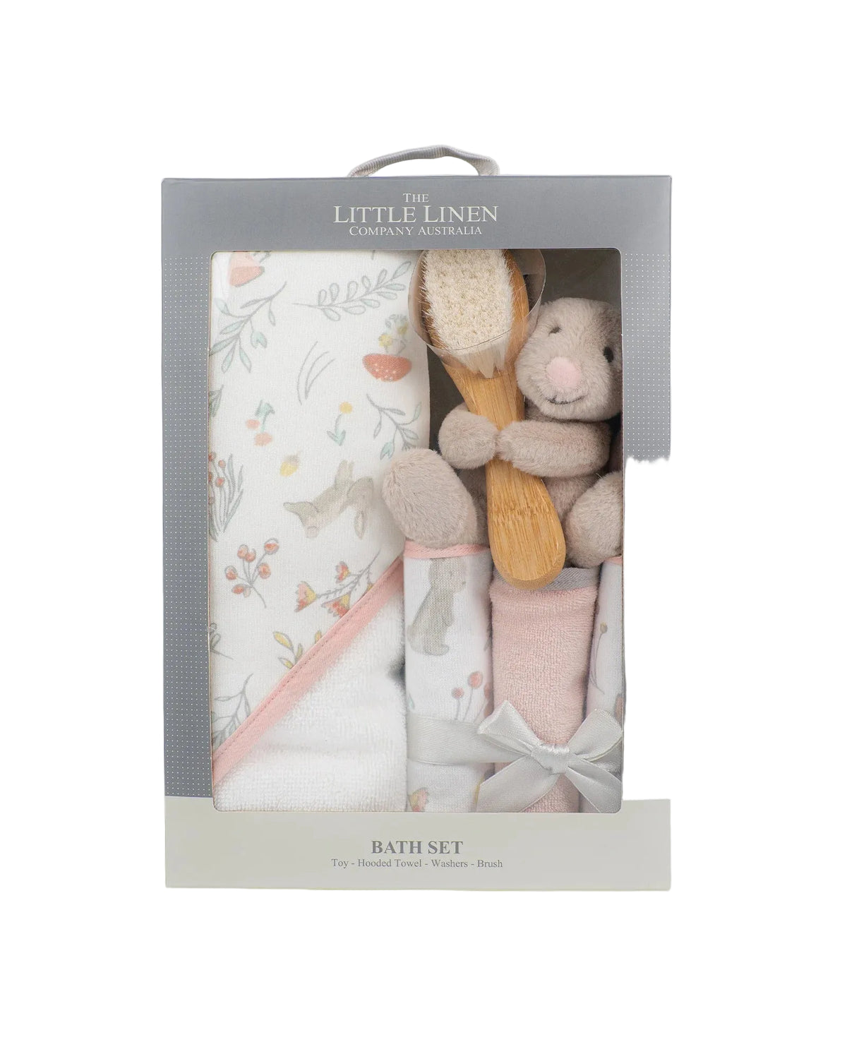 The Little Linen Company Australia Bath Set in a gray window box package, containing a floral-patterned towel, a pink and white sock, a plush bunny teether, and a wooden bath brush.