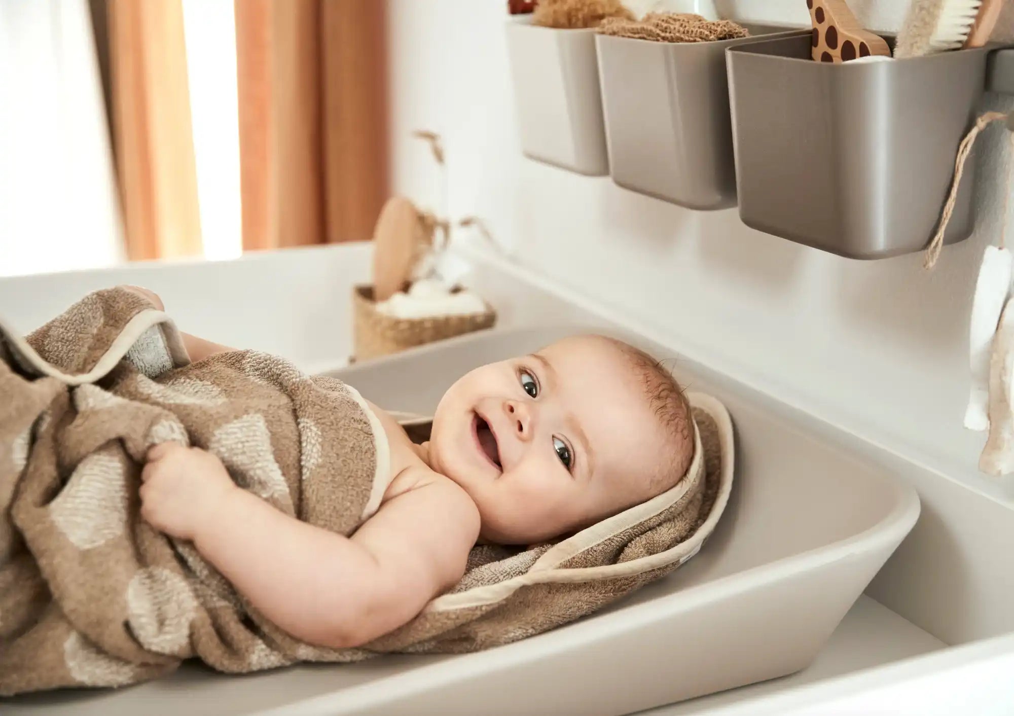 Smiling baby wrapped in a towel.